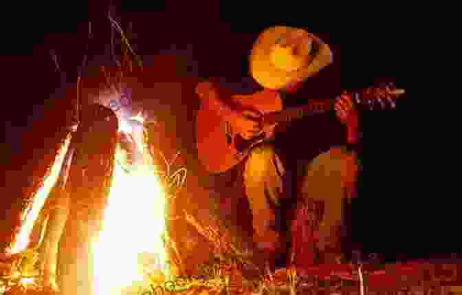 A Cowboy Sitting By A Campfire, Singing And Playing Guitar Songs Of The Western Frontier